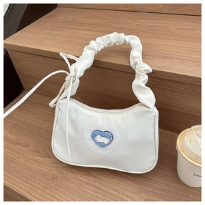 Detail of white pleated handle handbag with a blue plaid heart and rabbit pattern