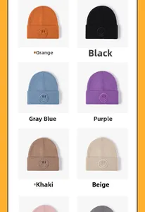 Detail view of smiley face embroidery on various colored knit beanies for winter