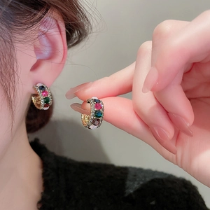 Detailed view of colorful rhinestone hoop earrings with high-shine gold plating on ear