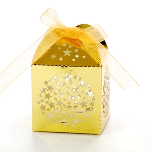 Macro detail of gold laser-cut star patterns and organza ribbon on the gift box