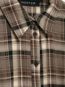 Close-up of the classic brown plaid shirt featuring standard collar and resin buttons