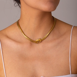 Detail of a double-layered gold snake chain necklace with a knotted centerpiece design