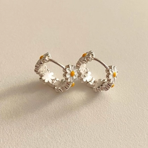 Detailed close-up of 925 sterling silver daisy hoop earrings with enamel flower design