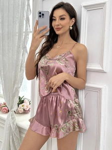 Detailed view of dark pink satin pajama set with floral print and ruffled hem