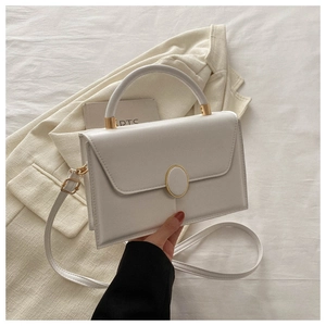 Détail d'un sac bandoulière blanc en similicuir avec fermoir doré et coutures fines