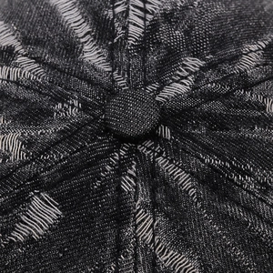 Close-up of vintage distressed denim baseball cap featuring frayed edges and button top