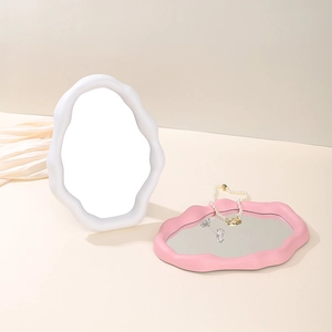 Close-up of cloud-shaped mirrors in pink and white with smooth matte resin frames