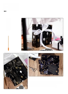 Detail of luxury black gift wrapping paper set with gold balloons and satin ribbons