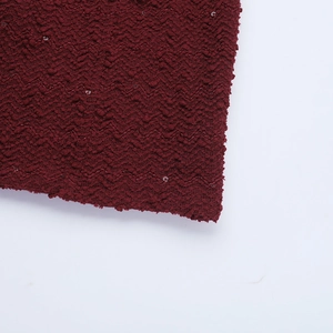 Gros plan sur le tissu en maille ondulée bordeaux avec paillettes argentées