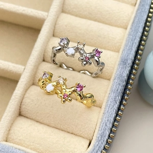 Bagues fleurs en or et argent avec zircons colorés présentées dans un écrin à bijoux