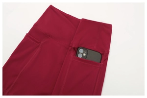 Close-up of burgundy high-waisted yoga leggings with functional side phone pockets