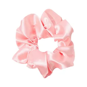 Pink silk satin oversized scrunchie hair tie with elegant pleated fabric texture