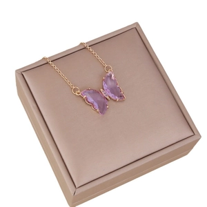 Elegant gold chain necklace with pink translucent glass butterfly pendant on a beige box