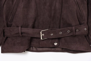 Detail shot of a dark brown suede jacket hem with a matching belt and silver metal buckle