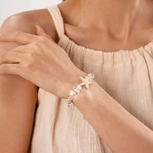 Détail d'un bracelet étoile de mer avec perles en cristal transparent sur un poignet