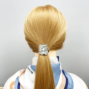 Silver flower hair tie with center pearl decoration on blonde hair back view