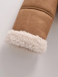 Detail der braunen Wildledermanschette mit dickem weißem Lammfellfutter und Steppnähten