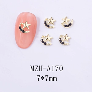 Detail of 7x7mm gold star and moon nail charms with black crystals on pink manicure