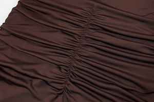 Detail of dark brown ruched fabric showing fine pleated texture and soft material drape