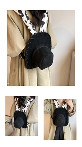 Detail of black cowboy hat backpack with stylish cow print shoulder straps in use