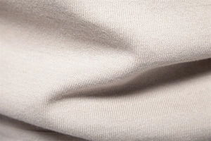 Macro shot of soft beige knit fabric texture on a premium men's business cardigan