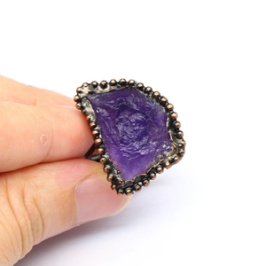Detailed close-up of a vintage bronze ring featuring a raw purple agate geode crystal