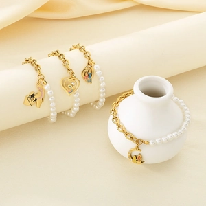 Detailed view of pearl and gold titanium bracelets with heart and moon charms