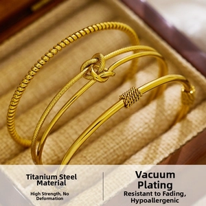 Detailed macro view of 18k gold plated stainless steel knot and twisted cuff bracelets
