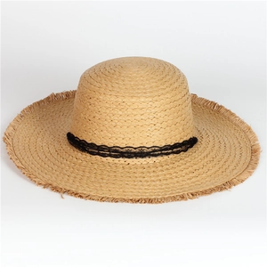 Detail of wide brim straw hat with black lace ribbon and stylish frayed tassel edges