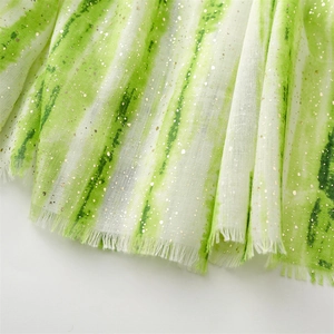Close-up of mint green and white linen-feel scarf with gold foil bamboo and fringe trim