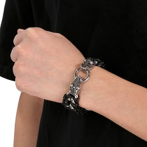 Detailed view of silver dragon head clasp on black braided leather bracelet