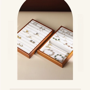 Detail of solid wood jewelry tray with soft beige velvet lining for rings and necklaces