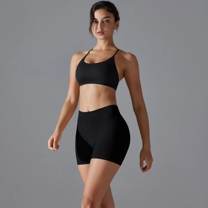Detail of a seamless black yoga set featuring a cross-back sports bra and high-waist biker shorts