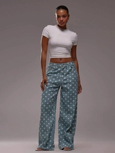 Close-up of blue wide-leg denim jeans with white polka dots and high-quality texture