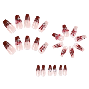 Macro detail of wine red and nude gradient press-on nails with 3D floral and pearl accents