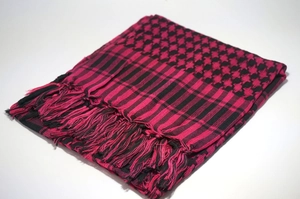 Detailed view of pink and black Keffiyeh desert scarf with traditional fringe tassels