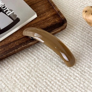 Macro d'une barrette à ressort en acétate ambre minimaliste avec base en métal argenté