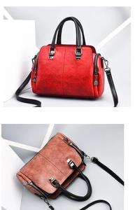 Detail of soft leather handbags in red and brown with silver hardware and shoulder straps