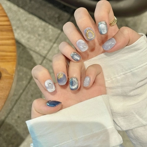 Short blue cat eye press-on nails with marble pattern, gold foil and luxury 3D accents