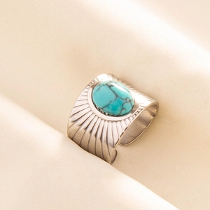 Close-up of bohemian adjustable steel ring with turquoise stone and radial texture