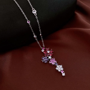 Detailed view of multilayer floral pendant with colorful zircons on a silver chain