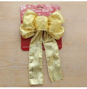 Close-up of golden glitter bow with wrinkled texture on a red snowflake card