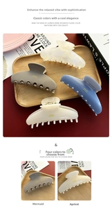 Detail of premium large acetate hair claws in ink blue and earth tones with gold lettering