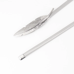 Close-up of silver metal spring belt with a detailed feather-shaped buckle clasp
