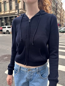 Détail du cardigan à capuche en maille bleu marine avec fermeture éclair et poches sur le mannequin