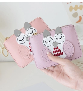 Detailed view of pink and purple cartoon owl coin purses with lychee texture and gold zipper