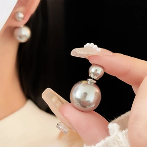 Detail of elegant silver grey double-sided pearl earrings with glossy metal finish