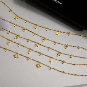 Gros plan de colliers dorés avec pendentifs en zircone en forme d'étoile et de cœur