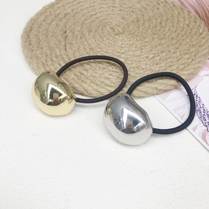 Elastic hair ties featuring gold and silver bean-shaped metal accents on woven mat