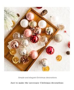 Flat lay of colorful Christmas ball ornaments with pine cones and orange slices on wood